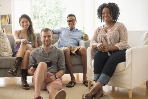 Portrait of group of friends sitting in living room.