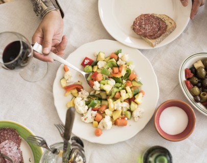 Hand serving salad.
