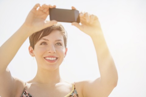 Young woman taking selfie with mobile phone.