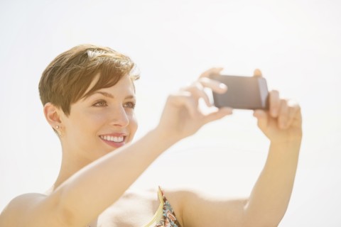 Young woman taking selfie with mobile phone.
