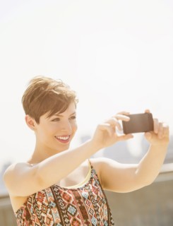 Young woman taking selfie with mobile phone.