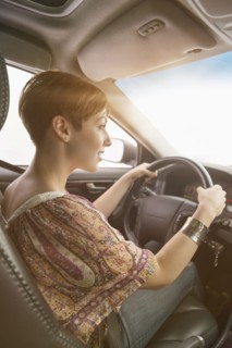 Side view of woman driving car.