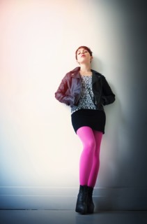 Woman wearing leather jacket, mini skirt and ping tights.