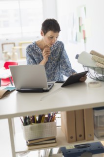 Senior business woman using tablet pc in office.