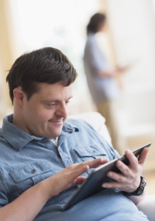 Man with down syndrome using tablet.