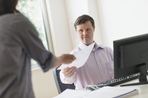 Man with down syndrome working in office.