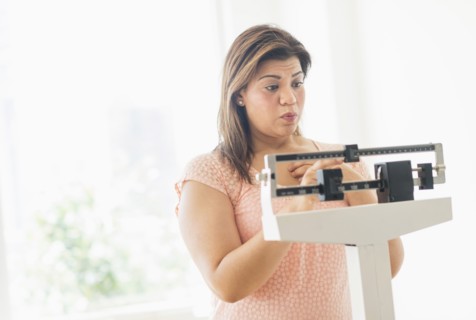 Woman standing on scale.