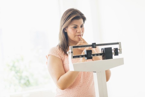 Woman standing on scale.