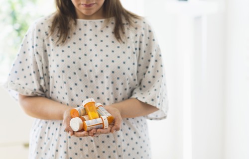 Woman with pill bottles in hands.