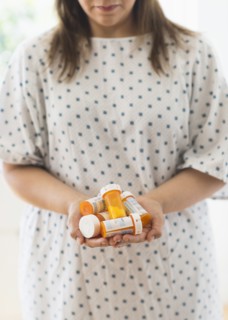 Woman with pill bottles in hands.