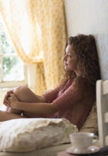 Portrait of woman sitting on bed.