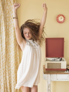 Portrait of woman dancing happily in room.