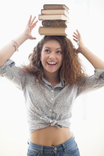 Portrait of woman with books on top of head.