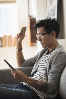 Man paying with credit card on tablet.