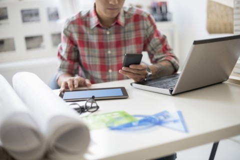 Man text messaging in office.