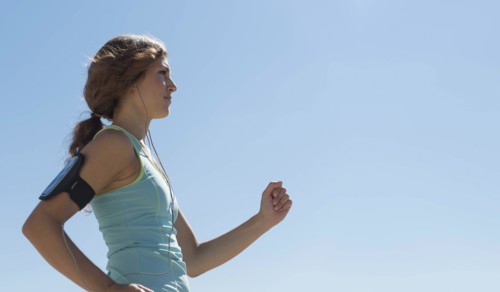 Side view of young woman jogging.