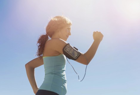Side view of young woman power walking.