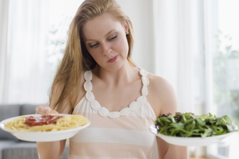 Woman choosing between pasta and salad
