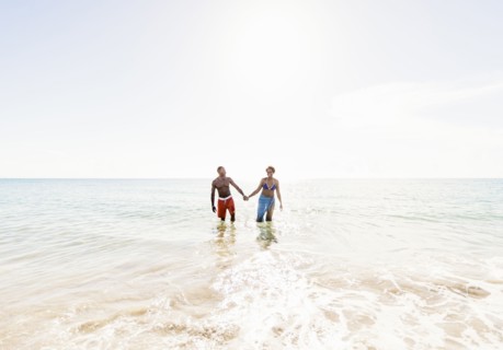 Man and woman holding hands on beach