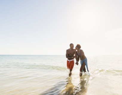 Man and woman holding hands on beach