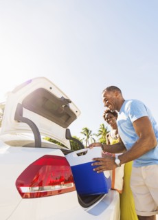 Mature couple loading car trunk