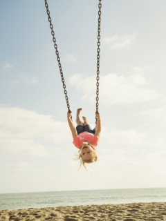 Girl (4-5) swinging on beach