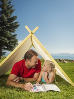 Father and daughter (2-3) playing in tent