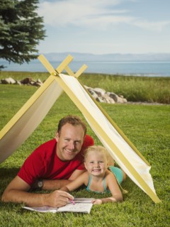 Father and daughter (2-3) playing in tent