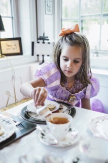 Girl (4-5) eating cookies at dining table