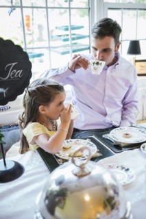 Father and daughter (4-5) eating together in dining room
