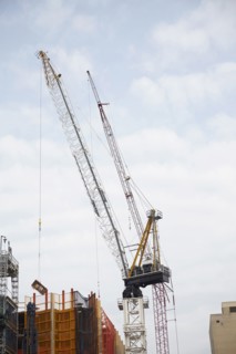 Cranes against cloudy sky