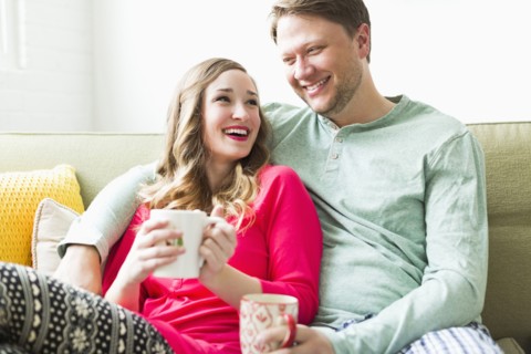 Young couple wearing pajamas sitting on sofa