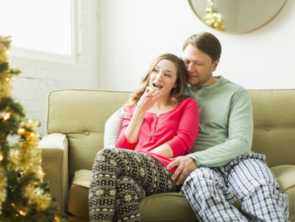 Young couple sitting on sofa at Christmas