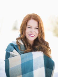 Portrait of mid adult woman wrapped in checked blanket