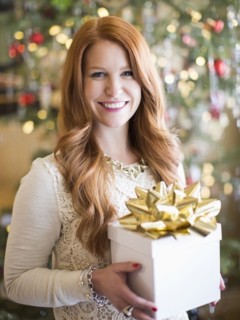 Studio shot of mid adult woman holding present in Christmas time
