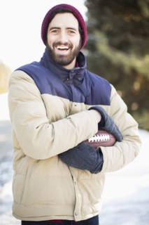 Portrait of man holding football outdoors