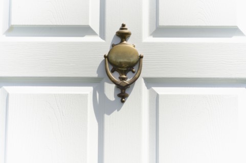 Close-up of white door with knocker