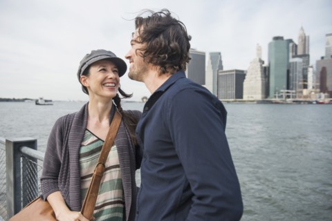 Happy couple standing against city skyline. Brooklyn, New York.