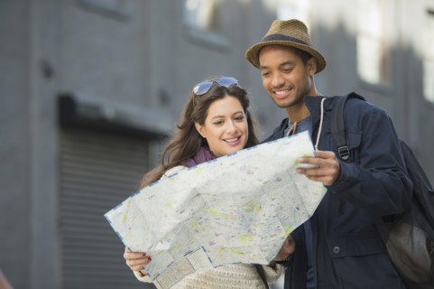Couple reading map on street.