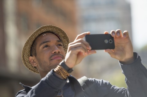 Man taking photo on street. .