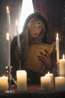 Portrait of sorceress in dark room.