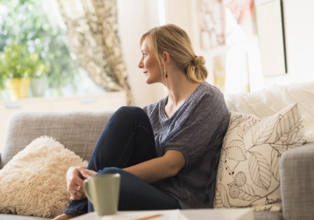 Woman sitting on sofa in living room.