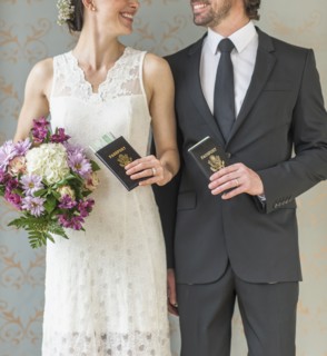 Happy bride and groom posing with passports.