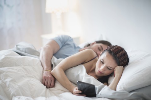 Couple in bed, Man sleeping, Woman using tablet pc.