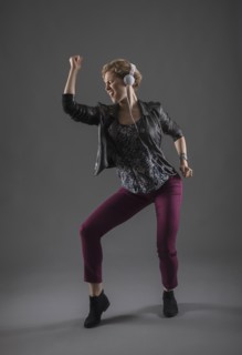 Studio shot of woman listening to music and dancing.