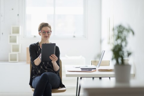 Businesswoman using digital tablet in office.