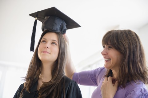 Teenage girl (14-15) getting ready for graduation ceremony