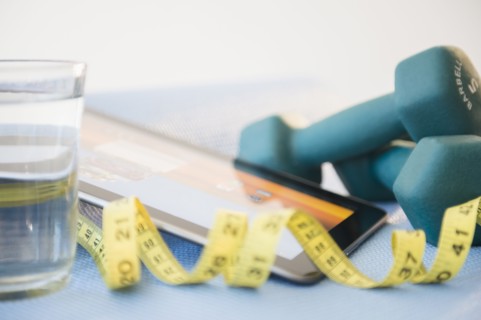 Dumbbells, tape measure and digital tablet