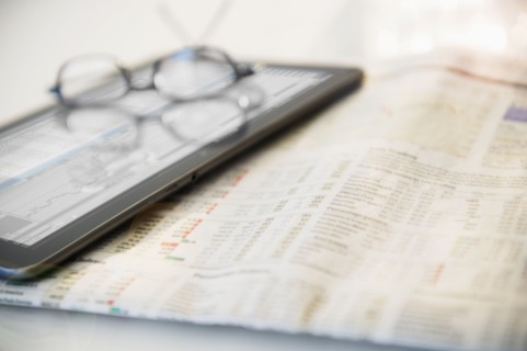 Newspaper, eyeglasses and digital tablet