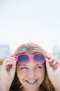 Girl (12-13) with pink sunglasses